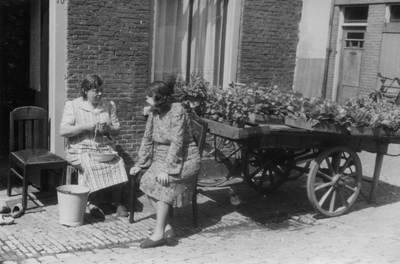 221136 Afbeelding van twee vrouwen voor het huis Kroonstraat 78 naast een kar met groentenplantjes; op de achtergrond ...